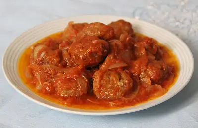 Albóndigas de sardinas en salsa de tomate con cebolla.